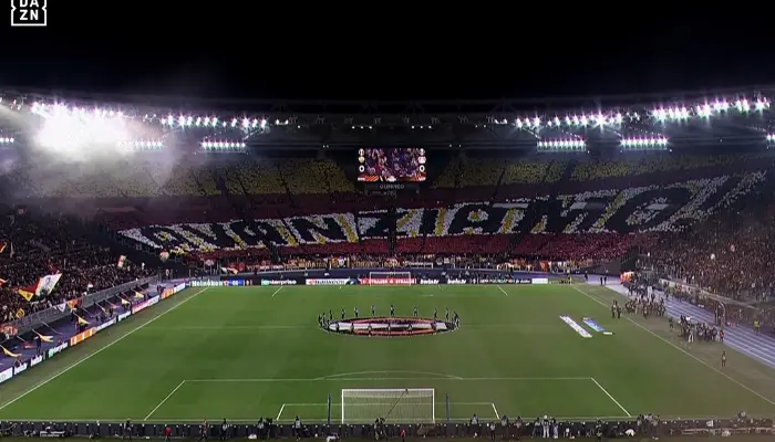 CĐV Roma dương cao khẩu hiệu 'Avanziamo' trên khán đài.