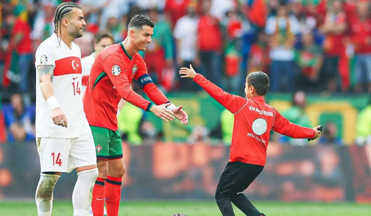 Ronaldo vui vẻ cùng CĐV nhí chạy vào sân.